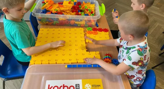 zdjęcie dzieci podczas nauki i zabawy z wykorzystaniem pomocy naukowych - klocków