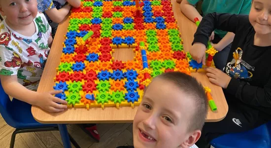 zdjęcie dzieci podczas nauki i zabawy z wykorzystaniem pomocy naukowych - klocków