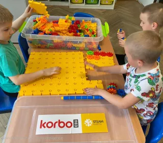 zdjęcie dzieci podczas nauki i zabawy z wykorzystaniem pomocy naukowych - klocków